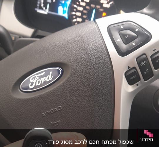 מפתח רכב פורד על רקע הגה ומד מהירות